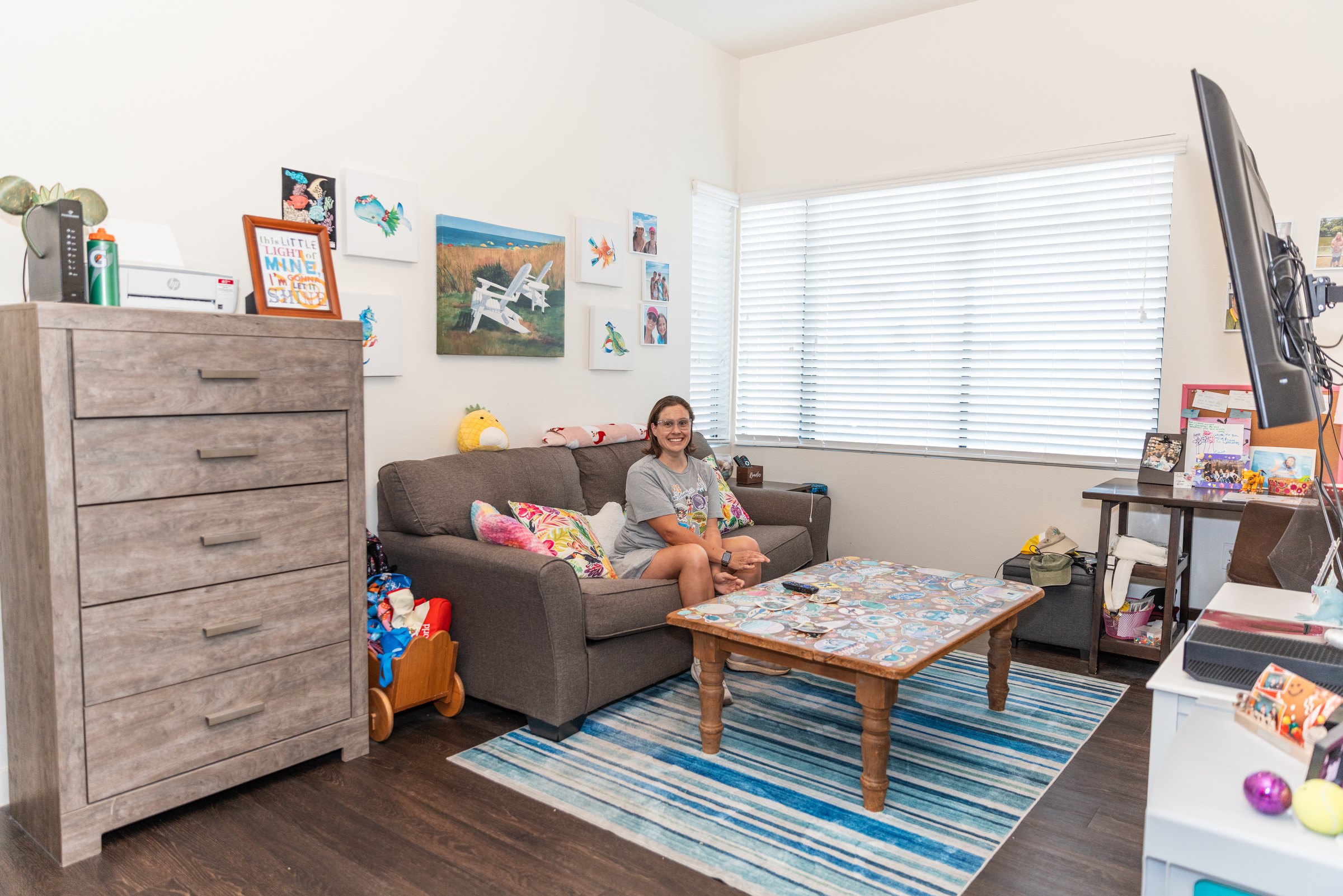A resident relaxing in her apartment at Treasure House